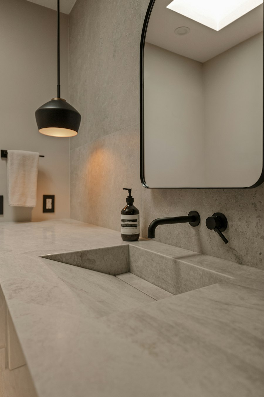 Détail d’une vasque en pierre et d’un robinet noir — photographie d’inspiration